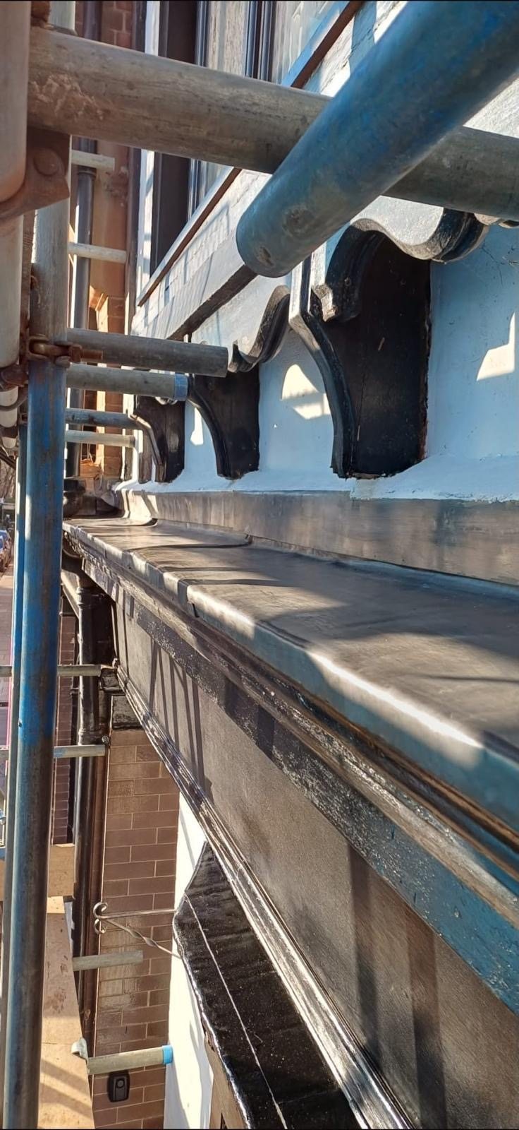 New lead-covered bay canopy on a period building, with scaffold alongside